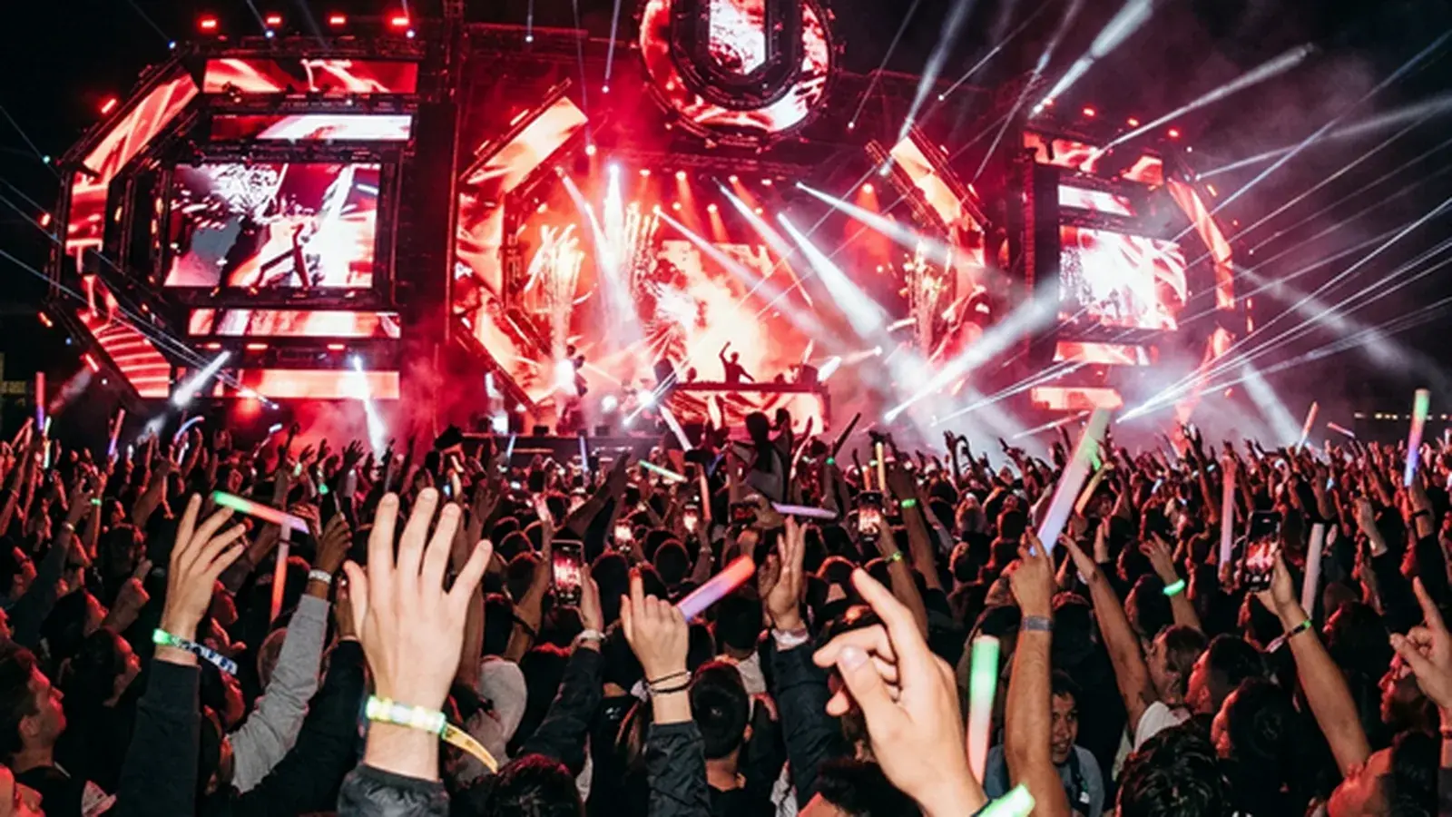Massive outdoor electronic music festival with LED stage and crowd