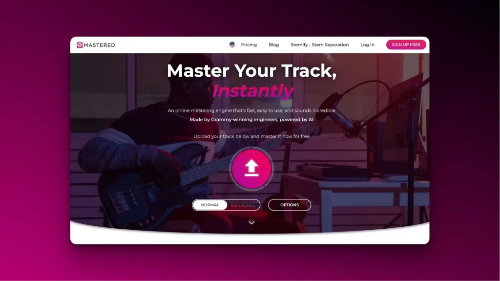 A musician strums a guitar by a microphone, with the website text proclaiming, “Master Your Track, Instantly.” Options and an upload button are visible on screen, powered by AI tools for music mastering.